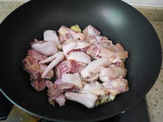 板栗烧鸡翅,热锅凉油，把大蒜和姜片放入锅中，煸炒出香味，把鸡肉倒入锅中。