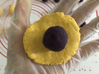 一颗小南瓜🎃,取一个南瓜小剂子，压平，放入一个紫薯球。