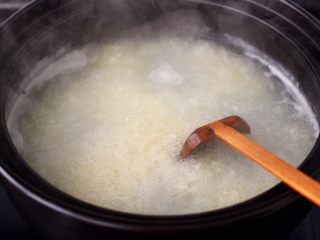 螃蟹青菜辣椒粥,盖上锅盖，继续小火焖煮至米汤汁变浓稠。