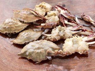 螃蟹青菜辣椒粥,把梭子蟹洗净后，打开梭子蟹盖，把里面的杂质去除干净后洗净。
