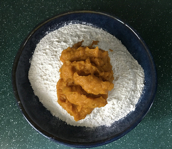 南瓜豆沙馒头,接着将南瓜泥分次加入面粉中，边加边用筷子搅成絮絮状