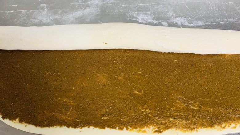 芝麻烧饼,均匀的涂抹上芝麻酱，从上向下卷起。