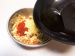香辣萝卜干,油烧冒烟后立即浇到蒜末和辣椒粉上面