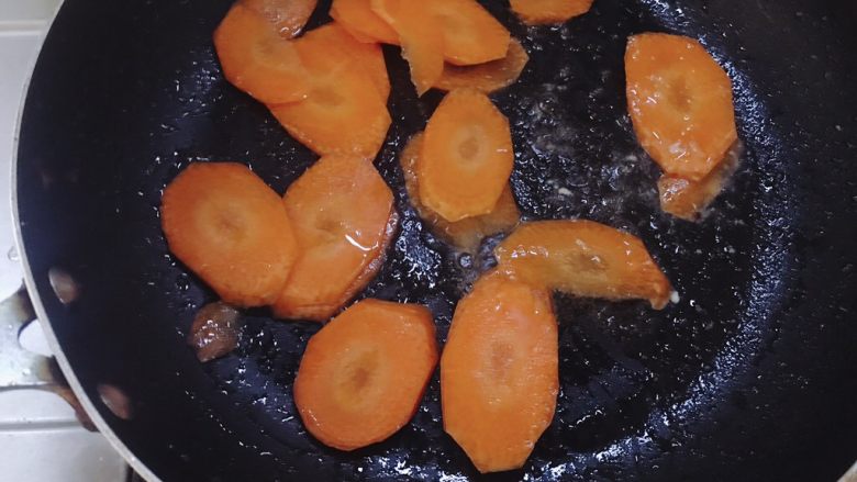 杏鲍菇炒肉片,锅里放少许油，先放入胡萝卜翻炒，胡萝卜比较难炒软所以最先下。