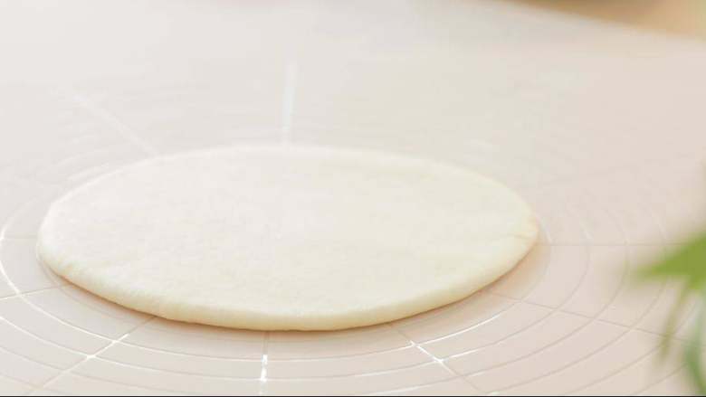 缤纷水果披萨,用擀面杖擀成薄饼。 我用的面粉量差不多做出6寸的批萨，所以擀到和6寸烤盘差不多大小即可。