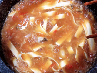 番茄牛腩面,将面条下入锅中，挑开面条，小火炖煮。