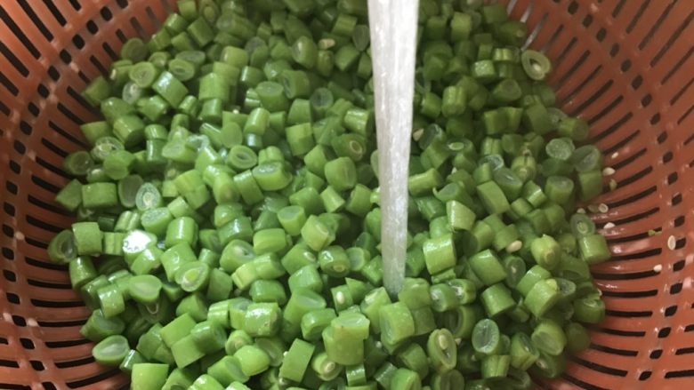 橄榄菜炒四季豆,捞出四季豆用冷水进行冲洗，这样做能保持脆爽。