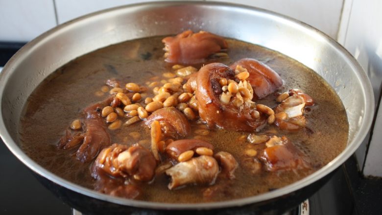 黄豆烧猪手,将电压力锅压制好的猪手倒入另外一款锅里，捞出调料弃之。
