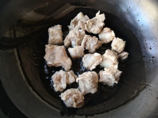 排骨豆角焖面,锅中适量油烧热后下入焯过的排骨。