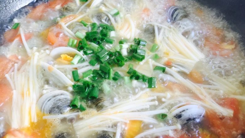 番茄菌菇蛤蜊汤,蛤蜊煮开口放入葱花即可关火