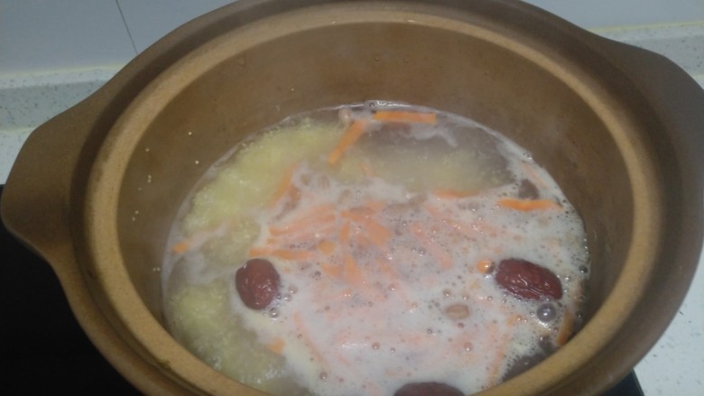 胡萝卜小米粥,大火煮开放入胡萝卜，转小火