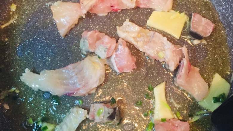 酸菜鱼,锅内热油，放入葱、姜、蒜煸香后倒入鱼骨，煎至两面发黄加水烧开