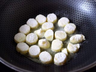 蔓越莓烩日式豆腐,锅烧热后，倒入花生油烧至六成热时，放入裹着淀粉的豆腐。