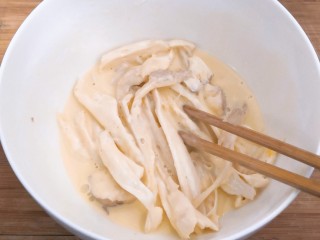 油炸杏鲍菇,用筷子，翻拌均匀，让每根杏鲍菇，都粘上面糊，备用