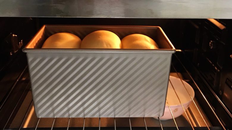 肉松吐司,放入烤箱中进行二次发酵，放一碗热水增加温度和湿度，发至九分满。