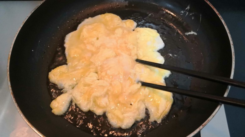 平菇炒鸡蛋,用筷子，划拨鸡蛋液，使鸡蛋液受热均匀，凝固断生