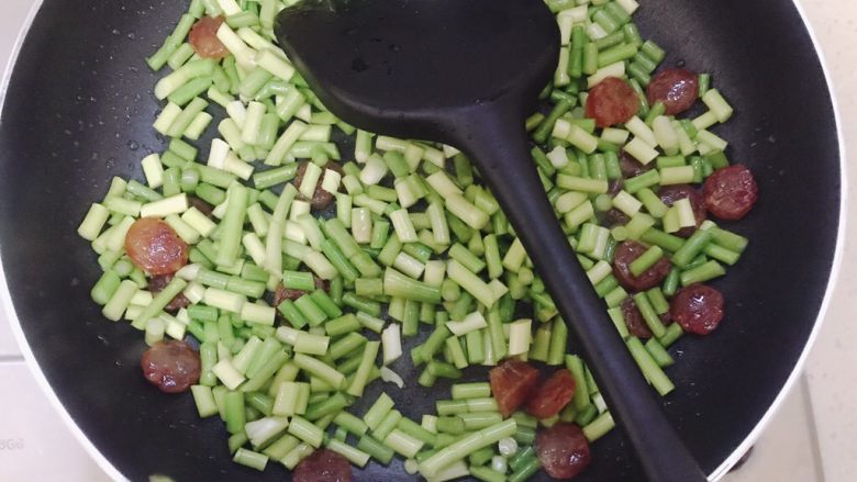 蒜苗炒腊肠,煎到腊肠透明就加入蒜苔，可以加点开水盖锅盖焖一会