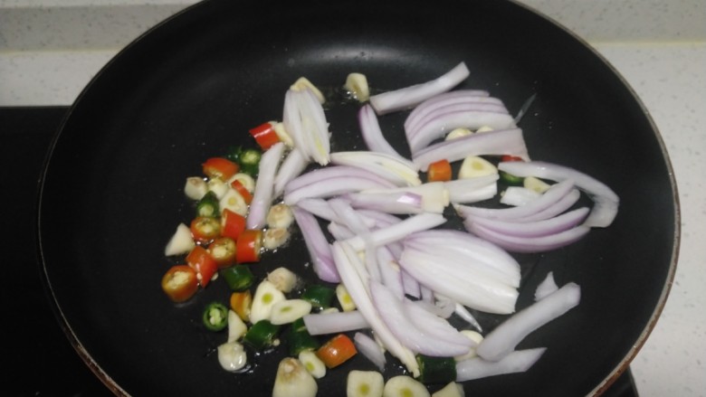 尖椒、洋葱炒小青菜,锅中放入适量油，放入尖椒、蒜瓣、洋葱