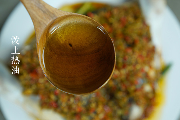 鲜辣剁椒,将热油泼在蒸好的鱼头上。