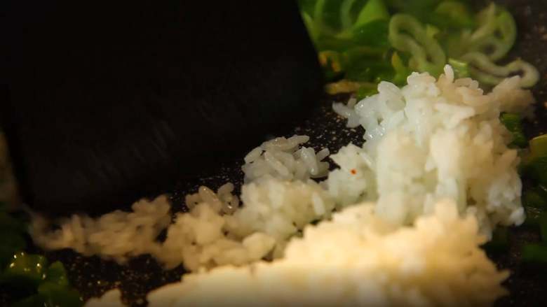 有家鲜厨房：卫龙炒饭,把米饭倒进锅中翻炒均匀。