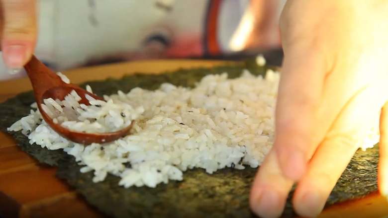 有家鲜厨房：韩国料理-紫菜包饭,紫菜铺好，放上米饭，用手铺满四分之三（注意不要太用力把米饭压扁）
