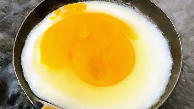 #冬日暖心菜#菠菜鸡蛋面,勺子涂抹一层薄薄的油打入鸡蛋放在开水中大火煮