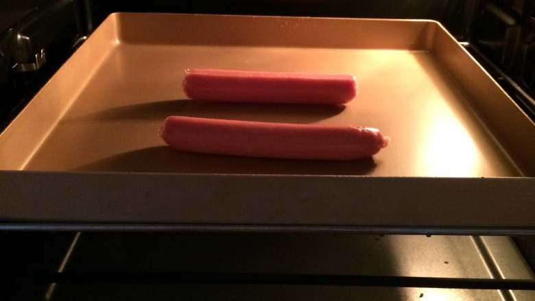 热狗面包,取2根<a style='color:red;display:inline-block;' href='/shicai/ 425'>香肠</a>，入烤箱210烤约7分钟。（我这里先做了2份所以烤了2根）