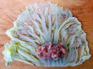 #冬日暖心菜#白菜包肉,白菜平铺在菜板上取适量的肉馅放在白菜上面