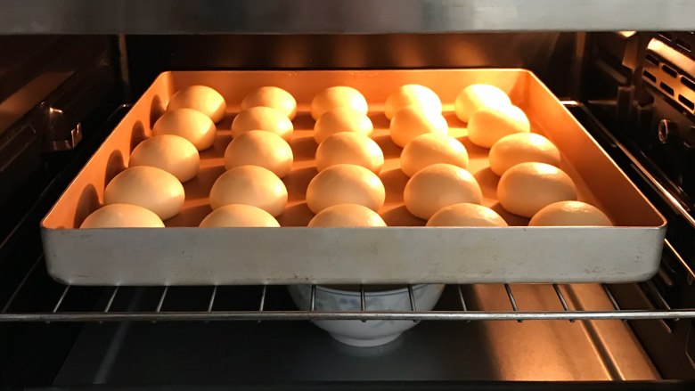 奶香面包,放入烤箱中发酵，放一碗热水增加温度和湿度，面团发至两倍大。
