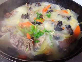 冬至美食+鸭架时蔬汤,最后放入盐和味精调味均匀撒上葱花和香菜提鲜即可出锅享用