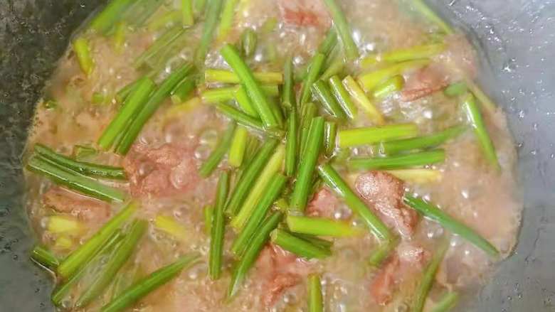 快手好吃的下饭菜蒜苔炒肉,加入适量清水，盖上盖子焖煮几分钟。