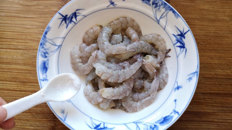 玉米炒虾仁,将处理好的虾仁放入碗中，加少量的盐。用手抓匀放置5分钟,(用盐先抓洗一下就可以洗去表面的黏液,这样炒出来的虾仁才会清脆好吃）。