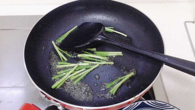 韭菜炒豆芽,用锅里的油炒菜，先放入韭菜的头。
