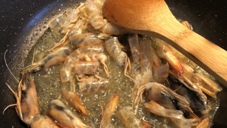 鲜虾什锦炒饭,锅里放多一些油，放入虾壳，炒出红油。炒的时候，把虾头部按压几下，把虾头里的膏要压出来。这是虾油的精华之处。大概要慢炒15-20分钟。中间油不够或者太少可以再加。