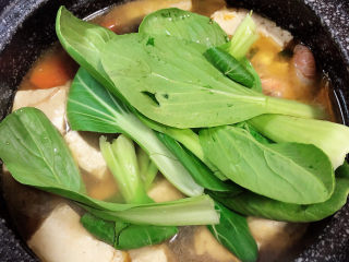海鲜豆腐煲,放入少量油菜点缀。