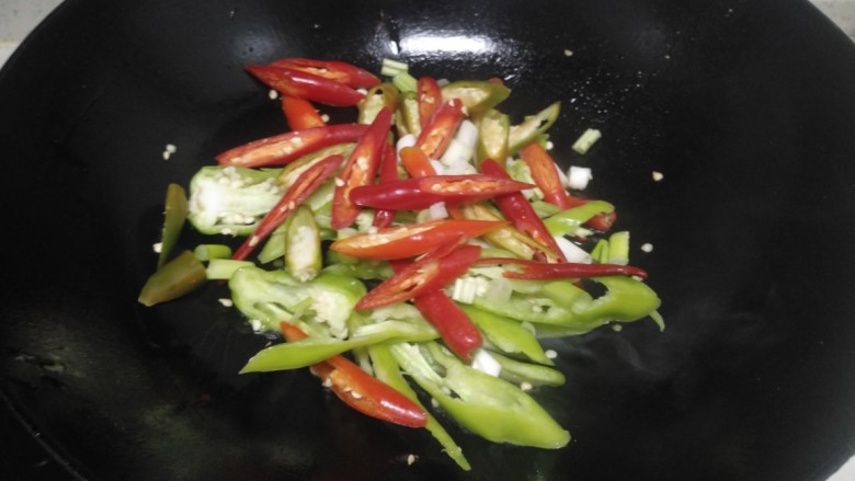 尖椒、蒜苗炒排骨,锅中放入适量油炒香青红椒、小葱