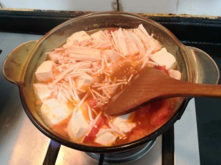 番茄金针菇汤,用勺子，搅拌一下，继续大火烧煮