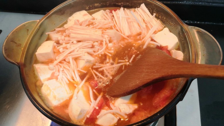 番茄金针菇汤,用勺子，搅拌一下，继续大火烧煮