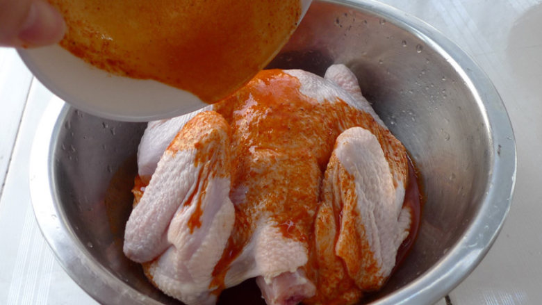 美味的新奥尔良烤鸡，做法简单方便,将调好的新奥尔良烤肉料汁倒入盛有全鸡的小盆中