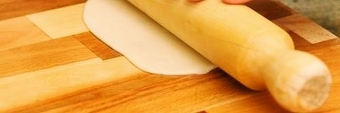 香酥牛肉饼,取一个长条，让擀面杖的方向跟长条方向一致，将其擀成宽度为8厘米左右的面片