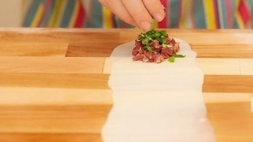 香酥牛肉饼,在面皮的一端放上适量的牛肉馅，再在上面撒上适量的青葱末