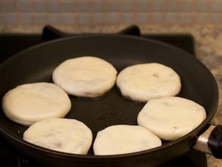 香酥牛肉饼,取一个平底不粘锅，在锅内加入花生油，将牛肉饼排列在锅底，中火煎制