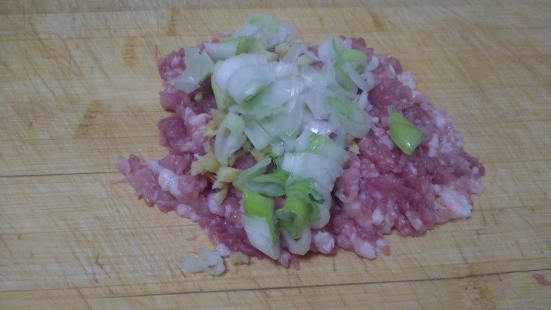虎皮尖椒酿肉,将葱和姜放在猪肉上