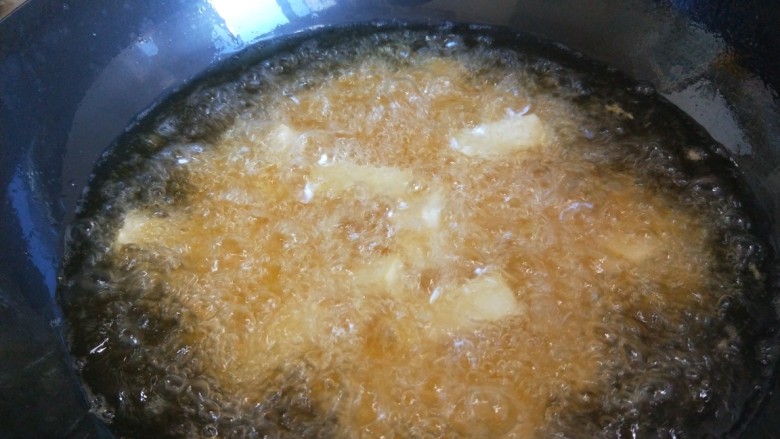 鱼香脆皮豆腐,油温要热，有烟冒出来就是70度左右，倒入豆腐炸制。