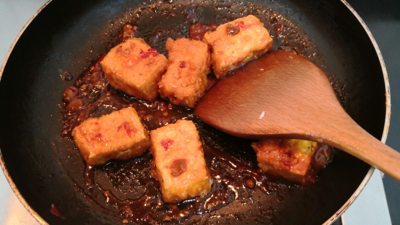 鱼香脆皮豆腐,用铲子，快速翻拌均匀，使豆腐裹上酱汁，关火，盛出