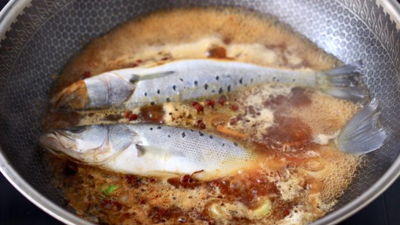 啤酒酱焖海鲈鱼,大火煮沸汤汁后，放入洗净的海鲈鱼。