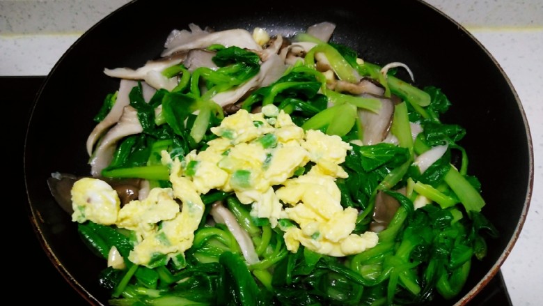 上海青炒平菇、鸡蛋,翻炒均匀，倒入鸡蛋