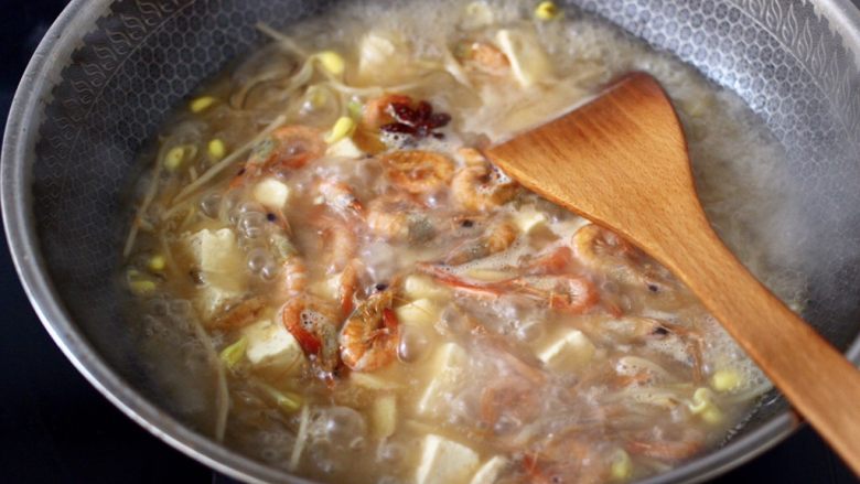 苔菜海虾粉条一锅炖,中火继续炖煮至汤汁，慢慢变得越来越浓稠时。