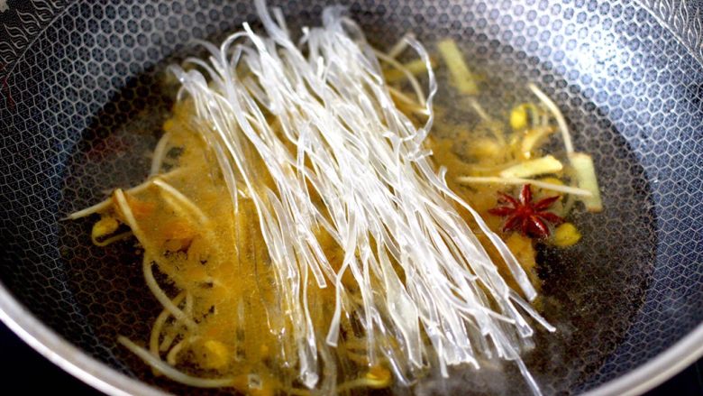 苔菜海虾粉条一锅炖,看见黄豆芽翻炒至变软后，锅中倒入适量的清水，先放入洗净的地瓜粉条。