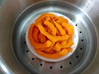 奶香南瓜麻花,南瓜放在蒸锅中蒸熟。